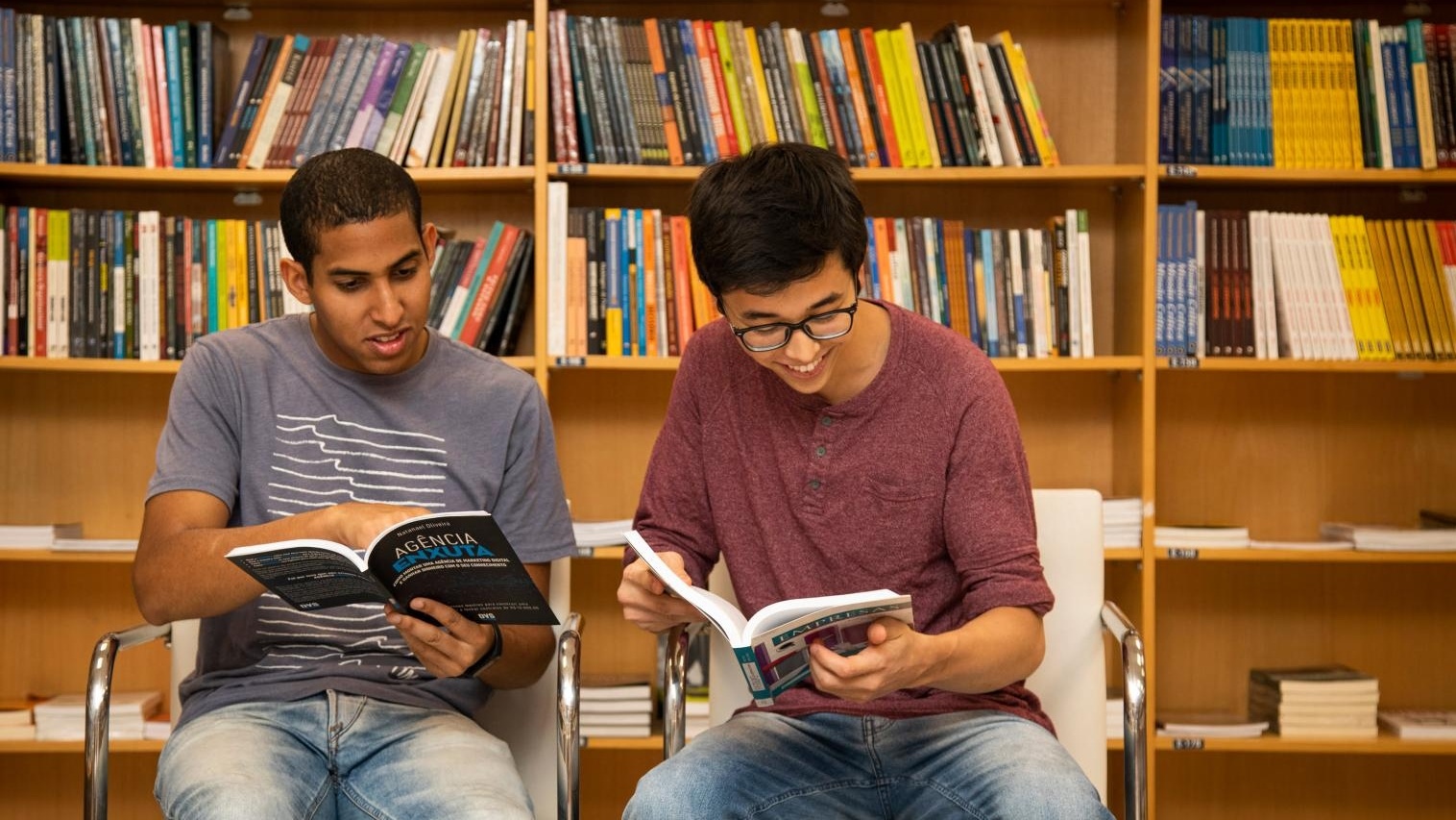 Dois aluno lendo livro na biblioteca