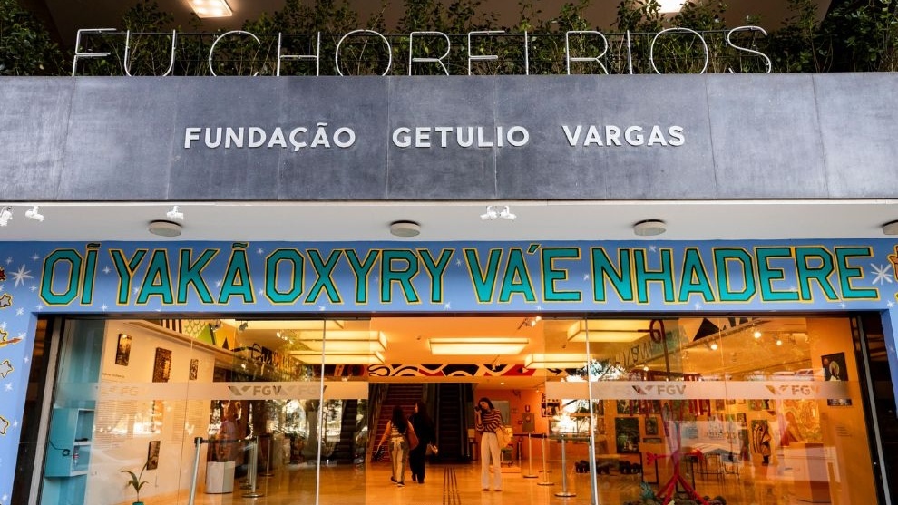 Fachada da Fundação Getulio Vargas com entrada de vidro e faixa colorida de exposição "Eu chorei rios".
