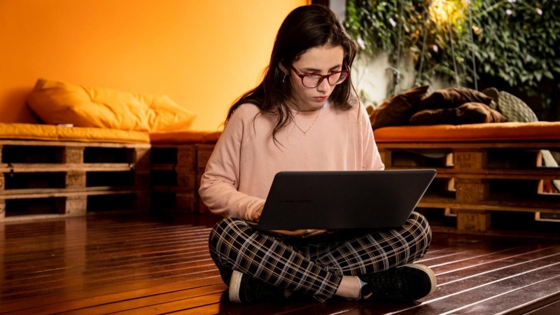 menina sentada mexendo no notebook