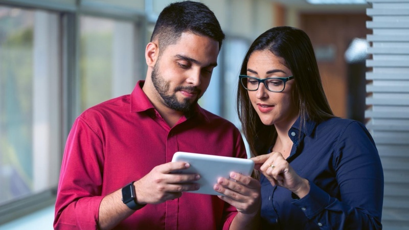 Rapaz e moça mexendo em tablet
