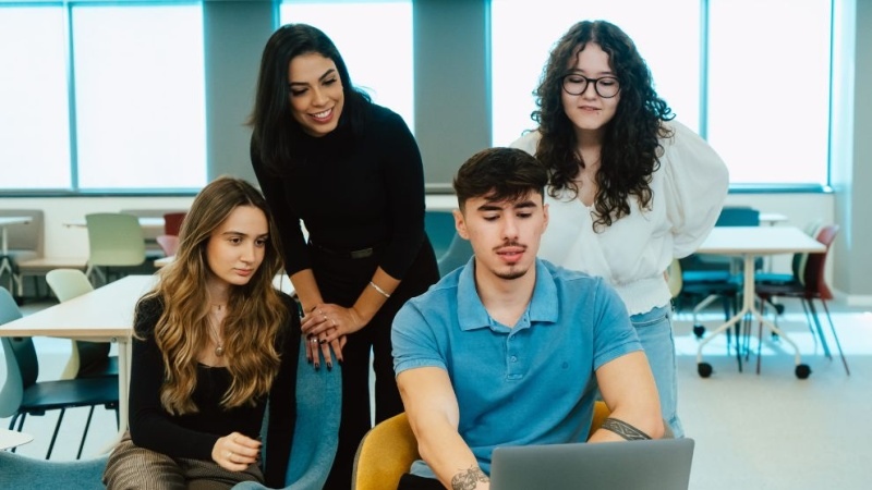 alunos reunidos em volta de um notebook