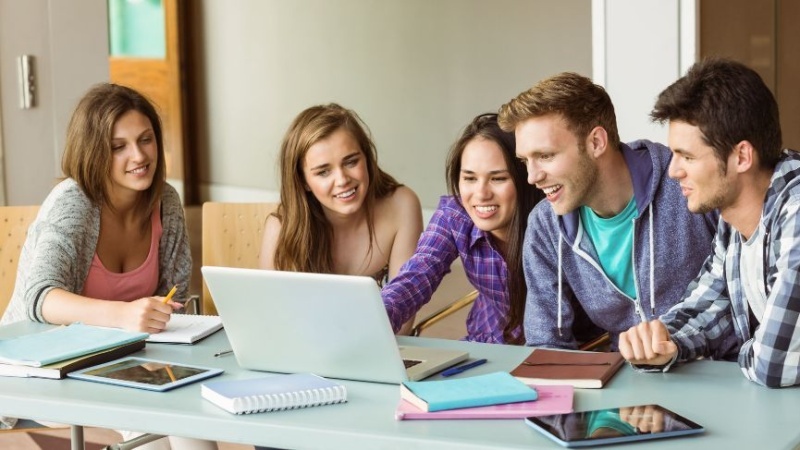 estudantes estudando em frente a um notebook