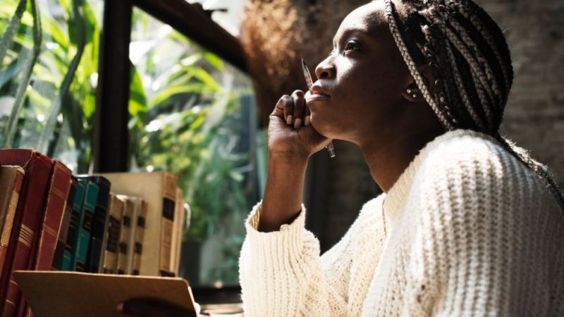 mulher negra em frente aos livros