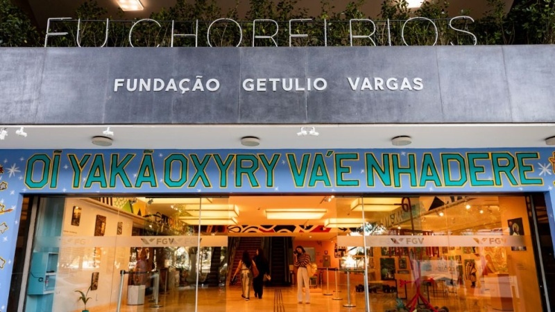 Fachada da Fundação Getulio Vargas com entrada de vidro e faixa colorida de exposição "Eu chorei rios".