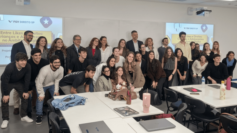 alunos reunidos em sala de aula sorrindo para foto