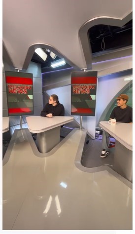 alunos sentados em uma bancada de telejornal