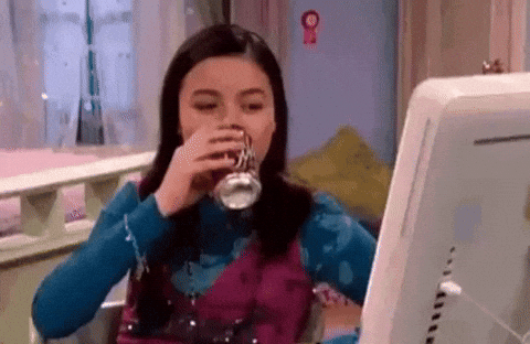 mulher bebendo refrigerante e olhando para o computador